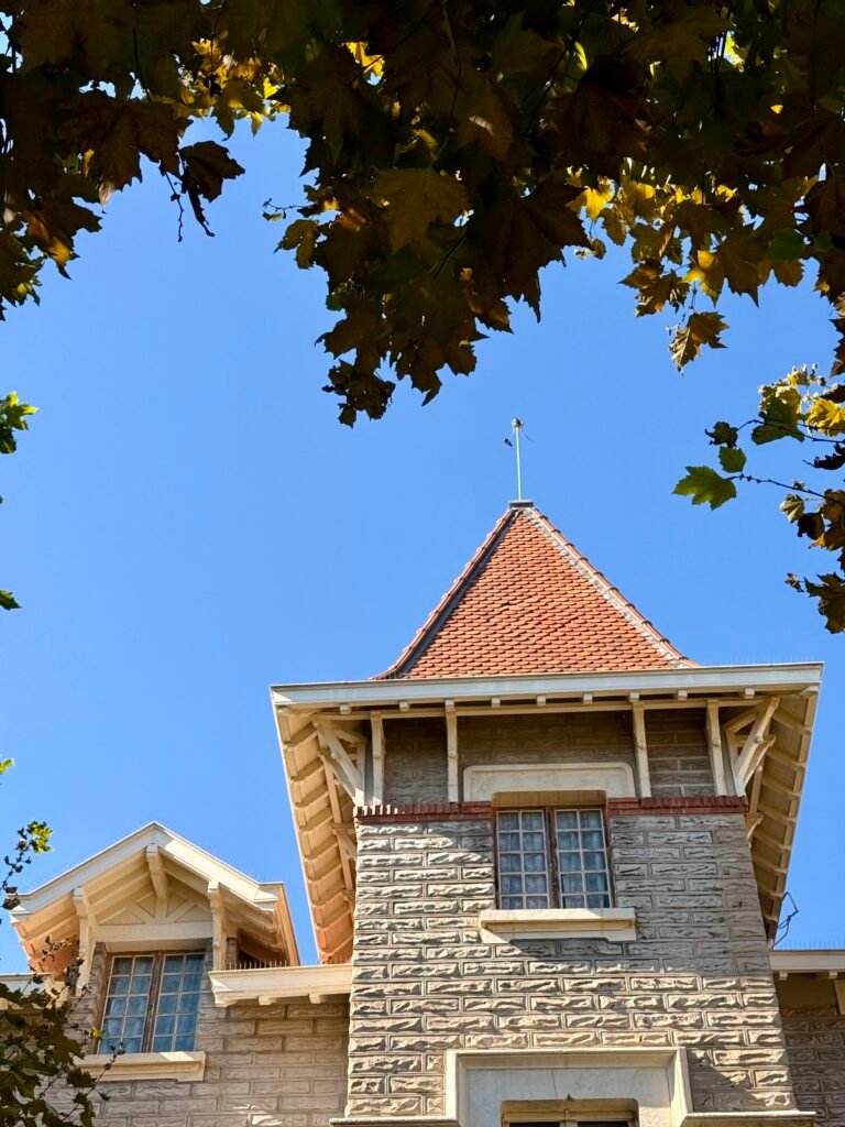 Tour en pierre coiffée d'une toiture en tuiles avec lucarne – rénovation de couverture par Maison Lardeux