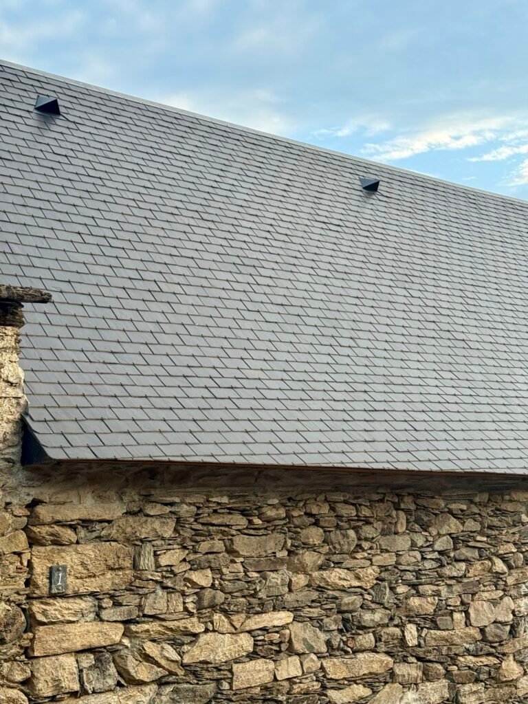 Grand pan de couverture en ardoise sur une bâtisse en pierre à Laruns