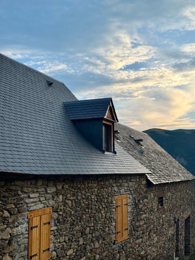 Couverture en ardoise et lucarne sur une bâtisse en pierre