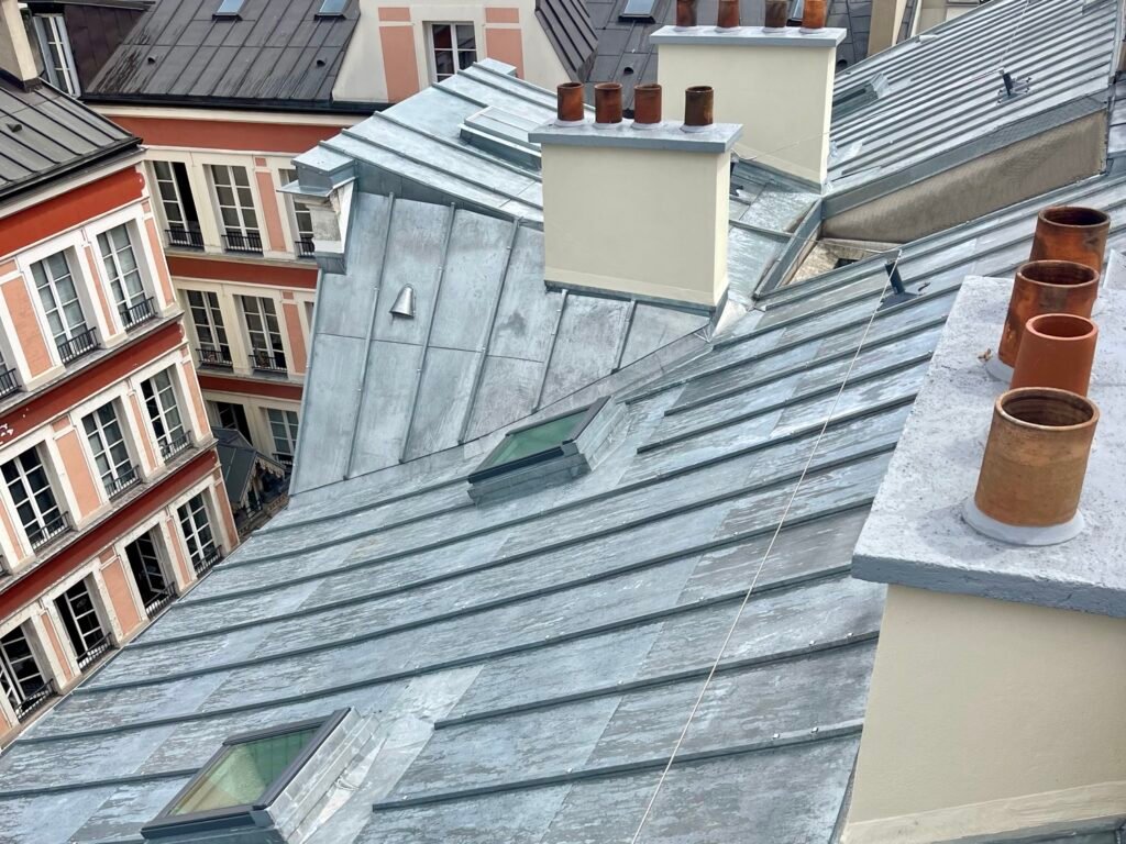 Fenêtre de toit et cheminée sur terrasse à tasseaux en zinc, Paris