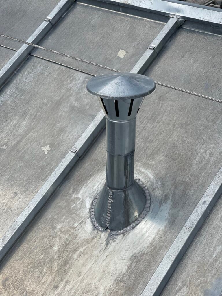 Chute de ventilation façonnée sur terrasse à tasseaux en zinc, Paris
