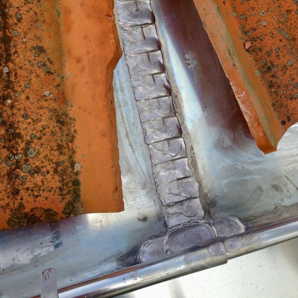 Soudure traditionnelle sur gouttière, chantier de zinguerie à Arbonne
